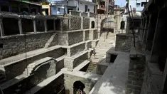 Orang-orang mandi di sumur tangga Bansilalpet berusia abad ke-18 yang sedang menjalani pekerjaan restorasi di Secunderabad, kota kembar Hyderabad, India (24/8/2022). (AFP/Noah Seelam)