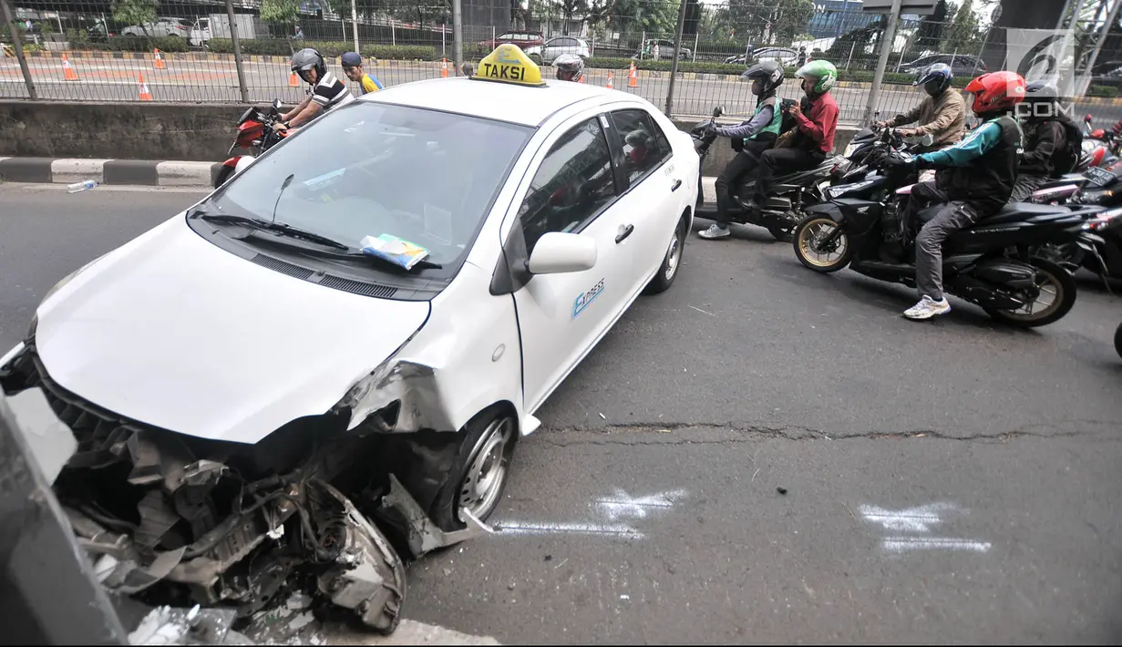 Pengendara sepeda motor tersendat saat melintasi lokasi kecelakaan taksi menabrak tiang di Jalan Ahmad Yani, Jakarta, Rabu (1/8). Kecelakaan menyebabkan kemacetan di jalur lambat persis di sebelah Gerbang Tol Rawamangun. (Merdeka.com/Iqbal Nugroho)