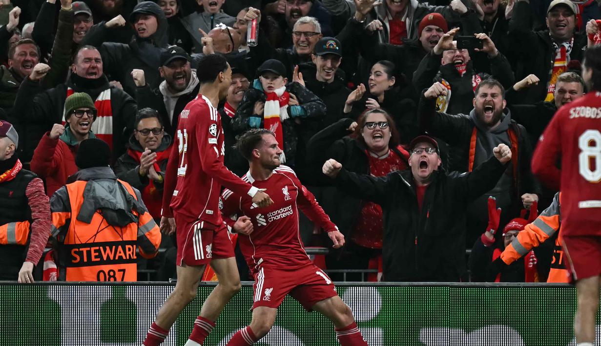 Gelandang Liverpool asal Argentina, Alexis Mac Allister (tengah) merayakan golnya dalam pertandingan pekan keempat Liga Champions 2025-2026 melawan Real Madrid di Stadion Anfield, Inggris, pada Selasa 4 November 2025 waktu setempat atau Rabu (5/11/2025) dini hari WIB. Liverpool sukses meraih kemenangan penting atas Real Madrid dengan skor tipis 1-0. (Paul ELLIS/AFP)
