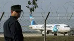 Seorang polisi berjaga di dekat pesawat milik maskapai Mesir, EgyptAir, yang dibajak dan dipaksa mendarat di Bandara Larnaca, Siprus, Selasa (29/3). Pembajak adalah seorang penumpang yang mengklaim membawa sabuk bahan peledak. (REUTERS/Yiannis Kourtoglou)