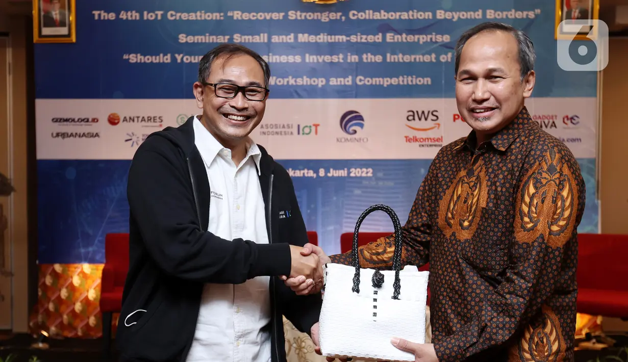 Ketua Umum Asosiasi Internet of Things Indonesia (ASIOTI), Teguh Prasetya (kiri) memberikan produk UMKM kepada Direktur Standardisasi Perangkat Pos dan Informatika, Direktorat Jenderal Sumber Daya dan Perangkat Pos dan Informatika (SDPPI), Kementerian Kominfo Mulyadi (kanan) pada Seminar Solusi Internet of Things untuk Usaha Mikro, Kecil, dan Menengah (UMKM) di Yogyakarta, Rabu (08/06/2021). (Liputan6.com/HO/Alwi)