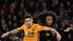 Penyerang muda Manchester United, Tahith Chong berebut bola dengan pemain Wolverhampton Wanderers, Rubver Vinagre pada babak ketiga Piala FA di Molineux, Sabtu (4/1/2020). Wolverhampton dan MU dipaksa untuk melakukan laga ulangan di Old Trafford setelah bermain imbang tanpa gol. (AP/Rui Vieira)