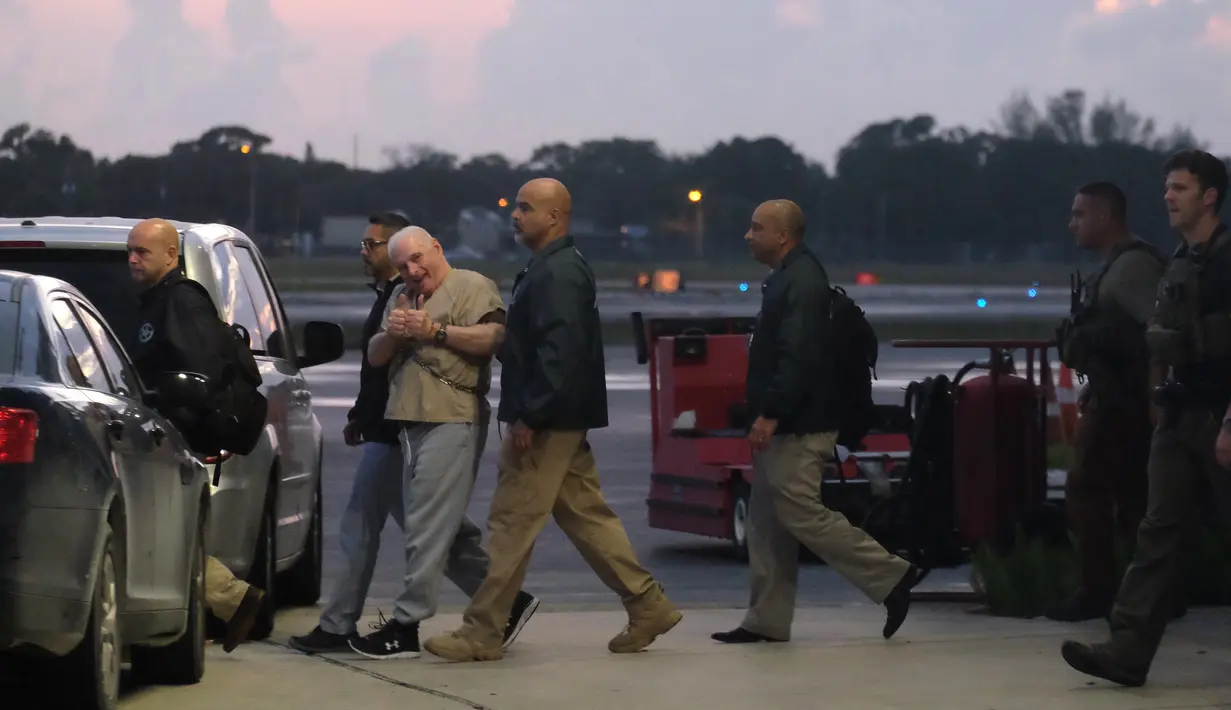Mantan presiden Panama, Ricardo Martinelli dikawal oleh Marshals AS saat diekstradisi dari Bandara Opa Locka, dekat Miami, Florida, AS, Senin (11/6). Martinelli diduga terlibat kasus spionase politik dan korupsi. (Gaston De Cardenas/AFP)