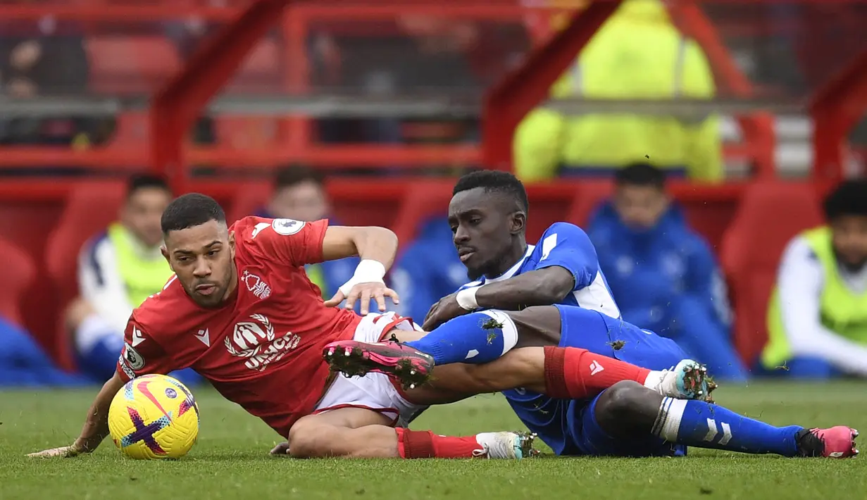 Gelandang Everton, Idrissa Gueye (kanan) dan bek Nottingham Forest, Renan Lodi terjatuh saat perebutan bola pada laga Liga Inggris 2022/2023 di City Ground, Nottingham (5/3/2023). Idrissa Gueye pernah jadi bagian PSG selama 3 musim sejak 2019/2020 hingga 2021/2022. Pada awal musim 2022/2023 ia memulai periode keduanya bersama Everton yang juga pernah dibelanya sebelum hijrah ke PSG. Bersama Alex Iwobi ia juga gagal mengangkat Everton musim ini. (AFP/Oli Scarff)