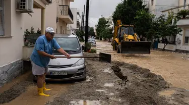 Warga membersihkan di area luar rumahnya usai tergenang banjir, Kota Volos, Yunani, Kamis, 28 September 2023. (AP Photo/Petros Giannakouris)