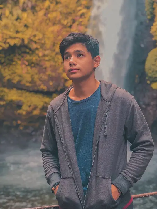 Wisata alam menjadi tempat favorit untuk melepas penat. Tak ketinggalan. Rayn Wijaya juga memilih untuk menikmati keindahan air terjun. Saat di air terjun, ia memilih gaya kasual dengan jaket yang dipadukan dengan kaus. (Liputan6.com/IG/@raynwijaya26)