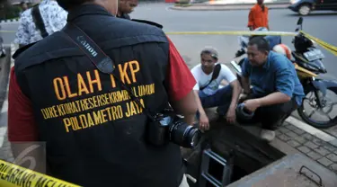 Aparat Kepolisian Polda Metro Jaya melakukan olah TKP di gorong-gorong Jalan Medan Merdeka Selatan, Jakarta, Sabtu (5/3/2016). Di gorong-gorong tersebut petugas menemukan sisa kulit kabel yang diduga menjadi penyebab banjir. (Liputan6.com/Johan Tallo)