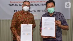 (ki-ka) Dirut PT Alita Praya Mitra Teguh Prasetya dan Kepala Balai Taman Nasional Bali Barat Dirjen KSDA dan Ekosistem Kementerian LHK,  Agus Ngurah Krisna menunjukkan naskah kerja sama pembangunan sarana komunikasi jaringan kabel serat optik di Bali, Kamis (27/10/2021). (Liputan6.com/HO/Alwi)