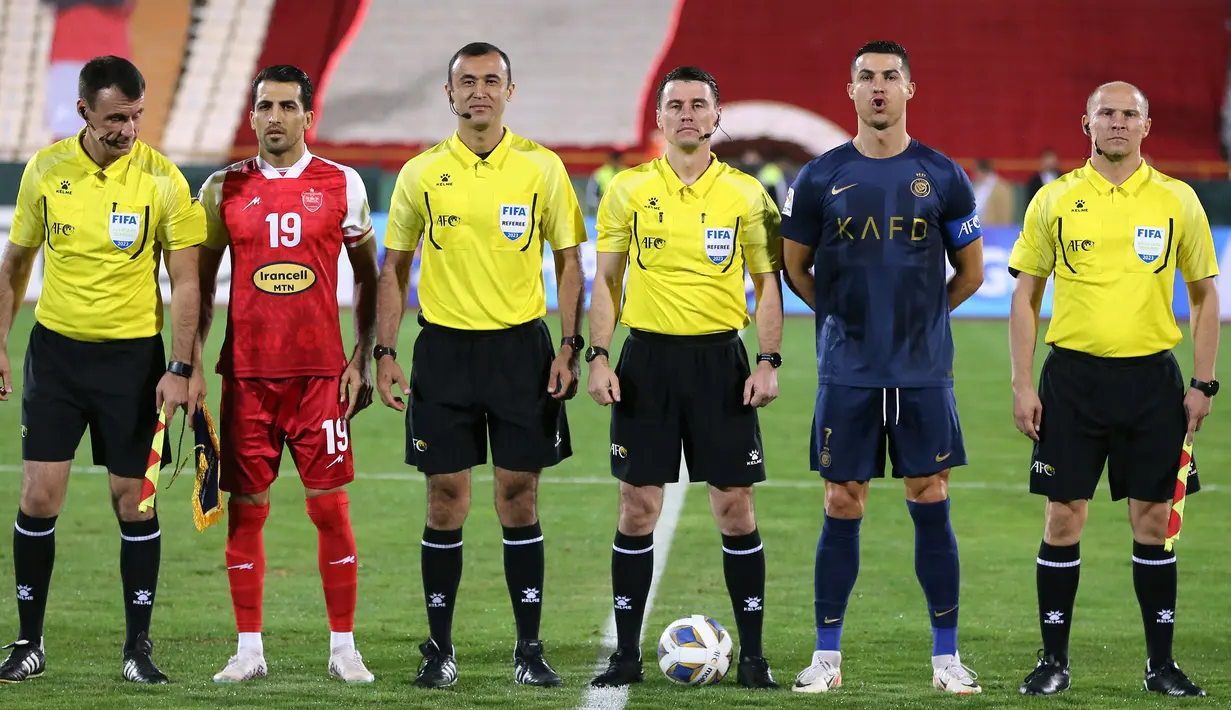 Pemain Al-Nassr, Cristiano Ronaldo (kedua kanan) berfoto bersama dengan kapten Persepolis, Vahid Amiri (kedua kiri) dan tim wasit yang bertugas saat laga Grup E Liga Champions Asia 2023/2024 yang berlangsung di Azadi stadium, Teheran, Iran, 19 September 2023. (AFP/Atta Kenare)