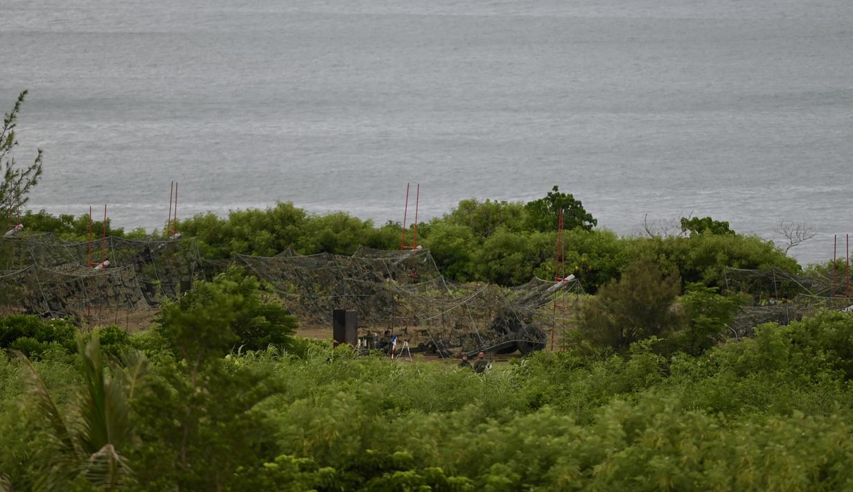Tentara militer Taiwan menjaga howitzer 155 inci selama latihan anti-pendaratan langsung di daerah Pingtung, Taiwan selatan (9/8/2022). Taiwan mengadakan latihan militer tembakan langsung, yang mensimulasikan pertahanan pulau itu dari invasi China, ketika Beijing melakukan latihan militer baru di sekitar tetangganya. (AFP/Sam Yeh)