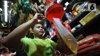 Pedagang tengah mengemas minyak curah di Pasar Kebayoran Lama, Jakarta, Jumat (15/7/2022). Berdasarkan Sistem Pemantauan Pasar Kebutuhan Pokok (SP2KP) Kementerian Perdagangan, harga minyak goreng curah hari ini, Jumat (15/7/2022) berada di level Rp15.200 per liter secara nasional. Harga ini tercatat turun yakni Rp15.236 pada Kamis (14/7/2022). (Liputab6.com/Angga Yuniar)