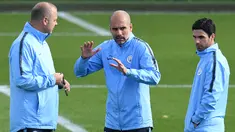 Pelatih Manchester City, Pep Guardiola (tengah) berbincang dengan asisten Mikel Arteta selama sesi pelatihan di City Football Academy, Inggris (18/9). City akan bertanding melawan wakil Prancis, Lyon pada grup F Liga Champions. (AFP Photo/Oli Scarff)