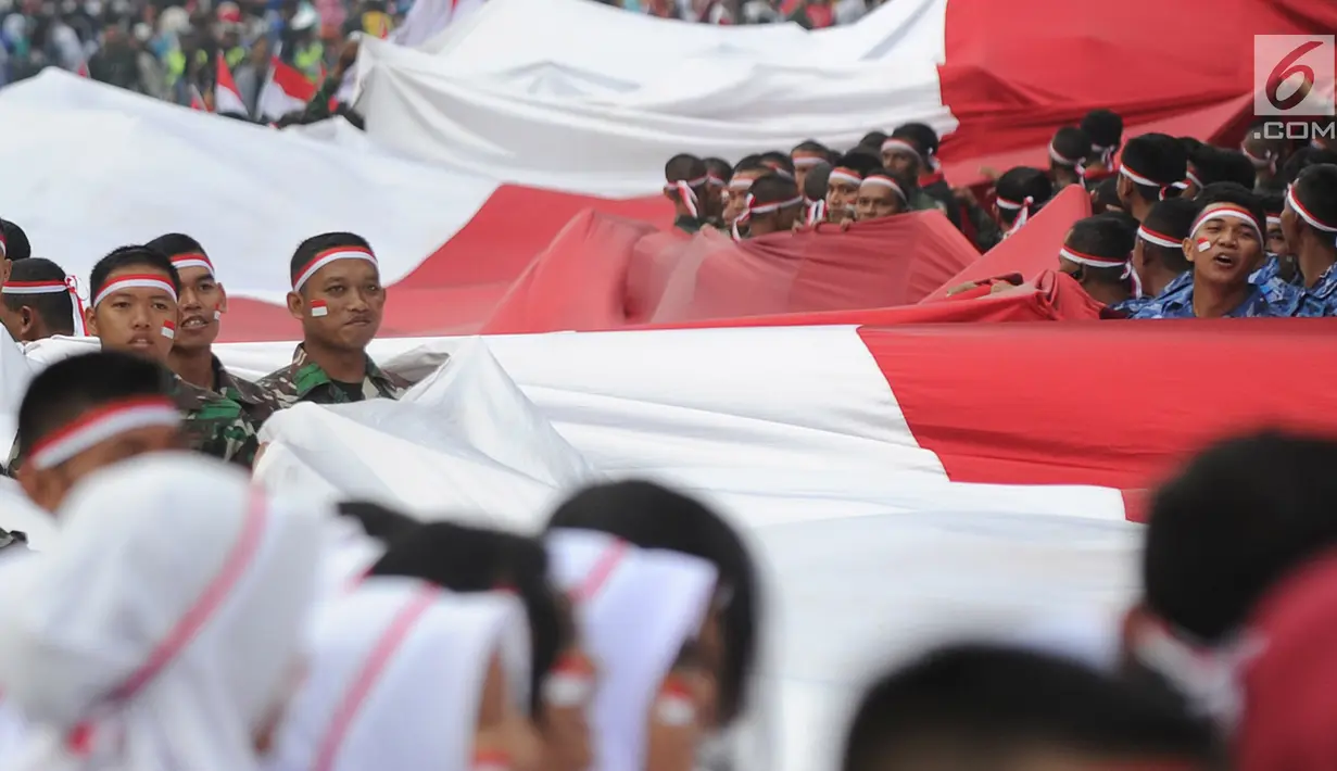 Anggota TNI POLRI  membawa bendera raksasa saat gelaran Festival Merah-Putih (FMP) 2018 di kawasan Air Mancur, Bogor,  Minggu (5/8). Kegiatan tersebut dalam rangka menyambut HUT Kemerdekaan RI ke-73. (Merdeka.com/Arie Basuki)