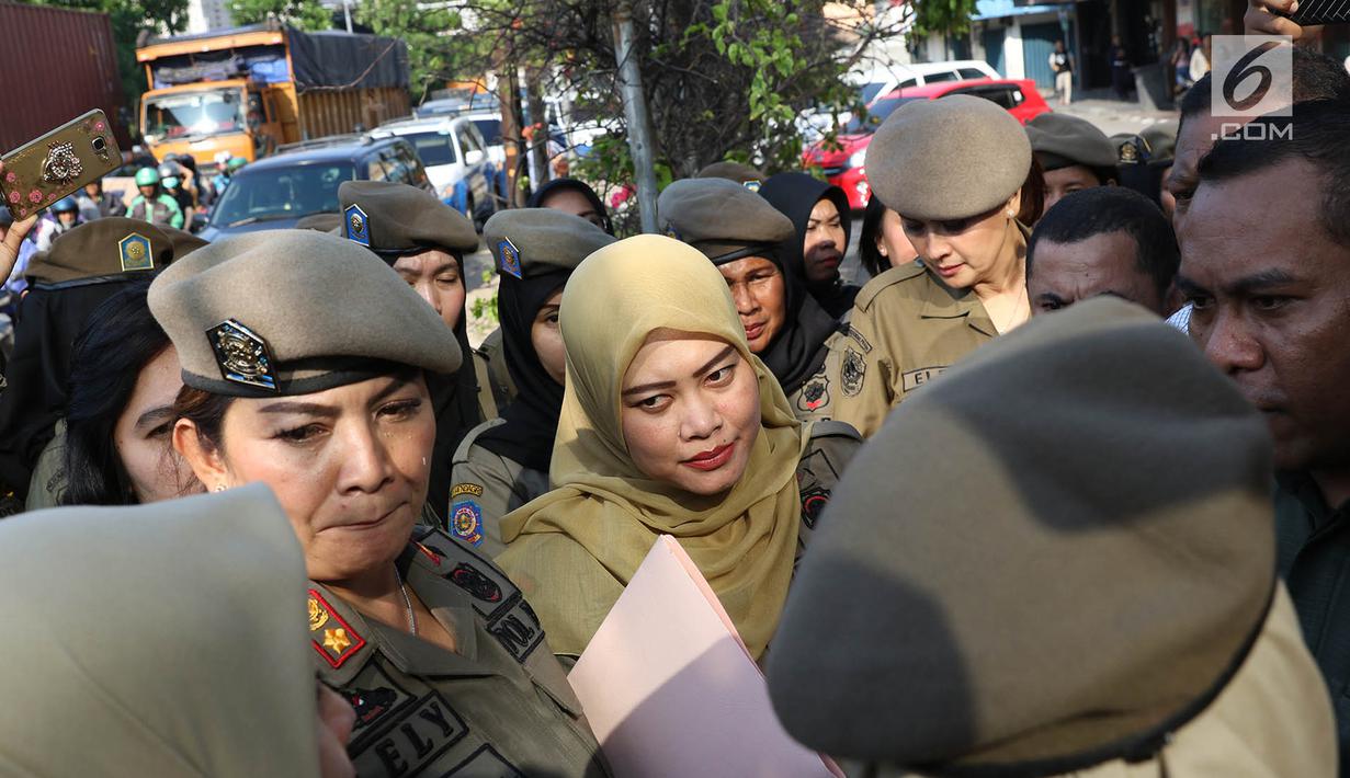 Sejumlah Satpol PP wanita berhadapan dengan petugas keamanan di depan Hotel Alexis, Jakarta, Kamis (29/3). Penutupan Hotel Alexis ditandai dengan pencabutan Tanda Daftar Usaha Pariwisata (TDUP) sejak Kamis, 22 Maret 2018. (Liputan6.com/Immanuel Antonius)