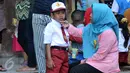 Salah satu orangtua menemani anaknya sebelum masuk kelas di SDN Manggarai 17 Pagi, Jakarta, Senin (18/7). Para orangtua terlihat ramai datang ke sekolah mengantar anaknya pada hari pertama masuk sekolah tahun ajaran 2016/2017. (Liputan6.com/Johan Tallo)