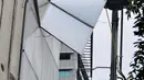 Petugas melepas plat aluminium pelapis dinding gedung Sekretariat Jenderal DPR RI yang roboh ditiup angin kencang di Kompleks Parlemen, Jakarta, Jumat (24/04/2015). Robohnya dinding karena usia gedung yang sudah lama. (Liputan6.com/Andrian M Tunay)