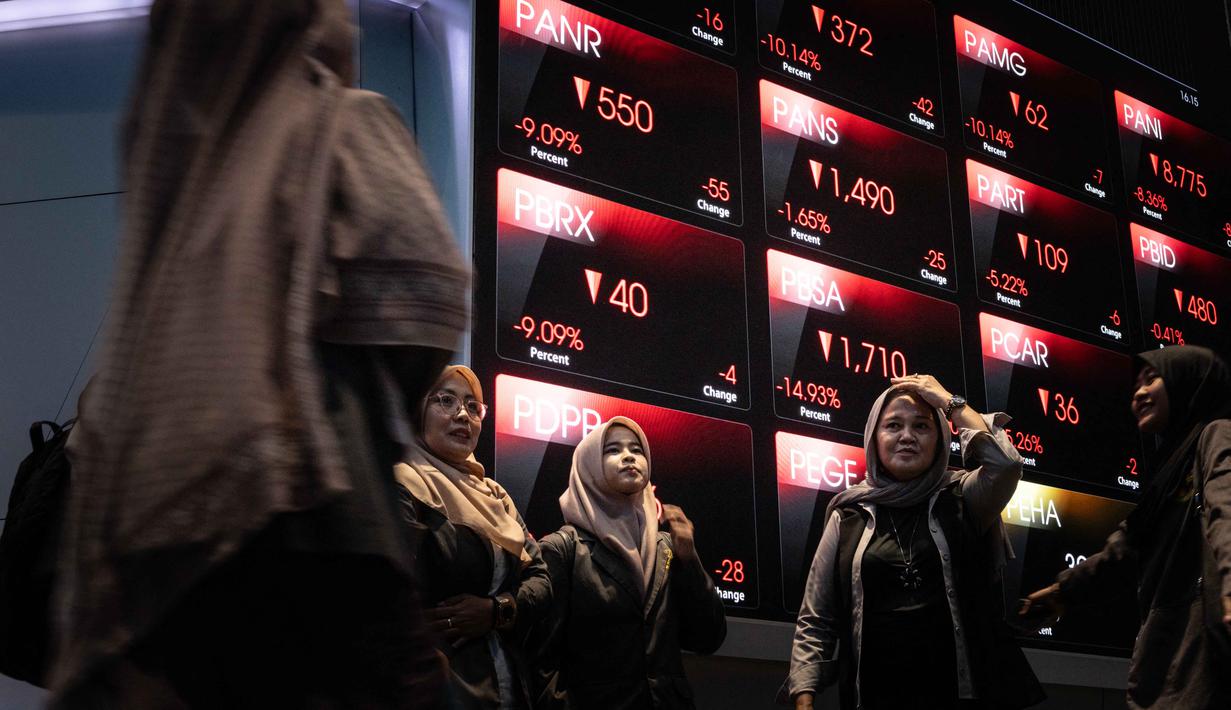 Berdasarkan data perdagangan RTI Business, IHSG melemah 8,0 persen ke level 7.654,66. Tampak dalam foto, pengunjung berfoto di depan papan elektronik yang menampilkan pergerakan Indeks Harga Saham Gabungan (IHSG) di Bursa Efek Indonesia, Jakarta, Kamis (29/1/2026). (YASUYOSHI CHIBA/AFP)