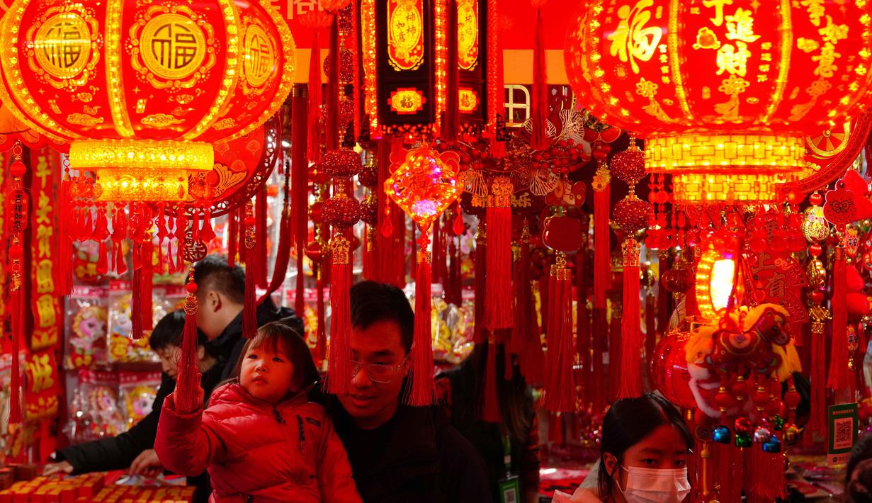 Orang-orang berbelanja dekorasi kemakmuran di sebuah stan untuk menyambut Tahun Baru Imlek, di sebuah Bazaar, Beijing, China, Minggu 1 Februari 2026. (AP Photo/Andy Wong)