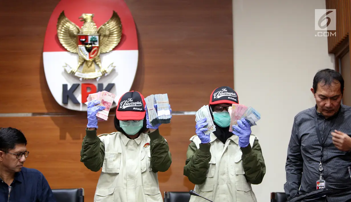 Penyidik menunjukkan barang bukti total uang Rp 279.920.000 dan USD 1.400 saat OTT Kalapas Sukamiskin di Gedung KPK, Jakarta, Sabtu (21/7). Kalapas Wahid Husein ditetapkan tersangka dalam dugaan suap jual fasilitas napi korupsi. (Liputan6.com/HO/Udin)