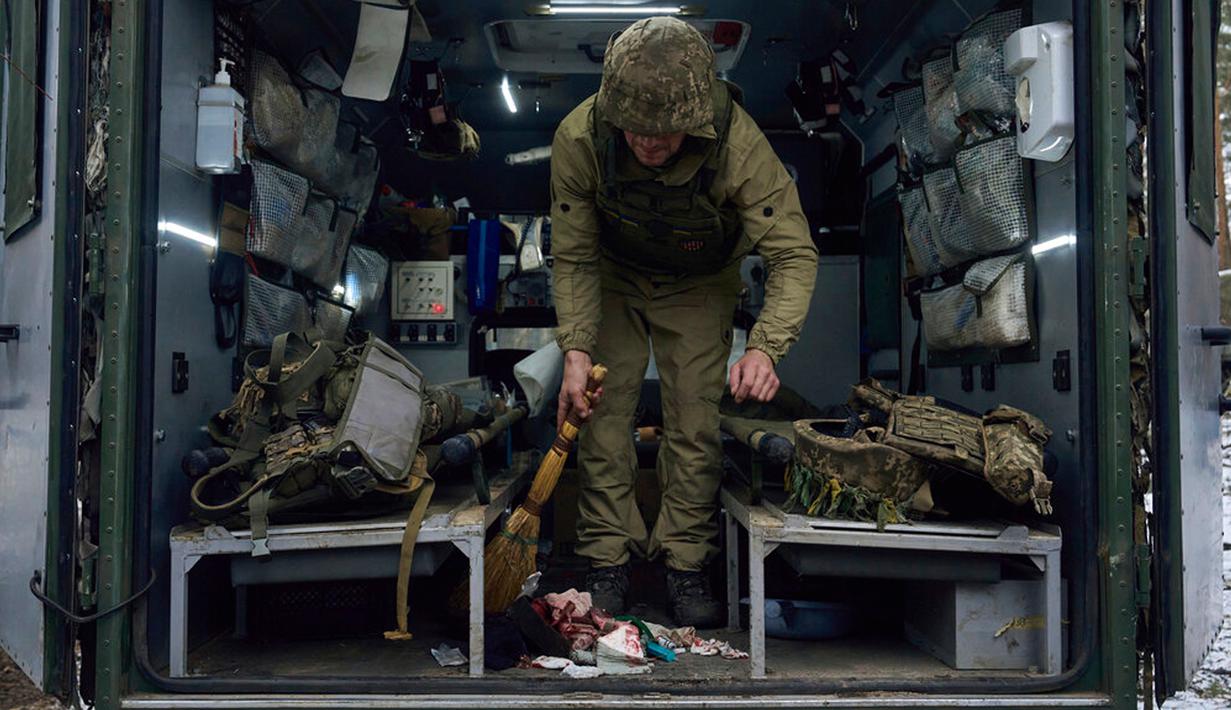 Petugas medis militer membersihkan kendaraan setelah memberikan pertolongan pertama kepada tentara yang terluka dalam pertempuran dekat Kremenna di wilayah Luhansk, Ukraina, 16 Januari 2023. Hingga saat ini pejabat Ukraina menolak untuk mengonfirmasi jumlah korban dalam perangnya dengan Rusia, setelah ketua Komisi Uni Eropa pada akhir November 2022 lalu memperkirakan bahwa "lebih dari 20.000 warga sipil dan 100.000 tentara Ukraina telah tewas di Ukraina hingga saat ini." (AP Photo/LIBKOS)