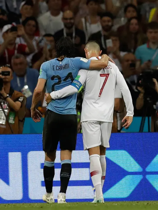 Penyerang Portugal, Cristiano Ronaldo memapah Penyerang Uruguay, Edinson Cavani yang Cedera keluar lapangan saat pertandingan babak 16 besar Piala Dunia 2018 di Stadion Fisht di Sochi, Rusia (30/6).  (AP Photo/Themba Hadebe)
