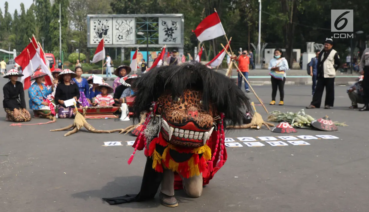 Salah satu tarian Kendeng ditampilkan saat aksi di depan Istana Negara, Jakarta, Kamis (2/8). Dalam aksinya, mereka melakukan tradisi Brokohan atau makan bersama nasi aneka urap yang sebelumnya didoakan. (Liputan6.com/Helmi Fithriansyah)