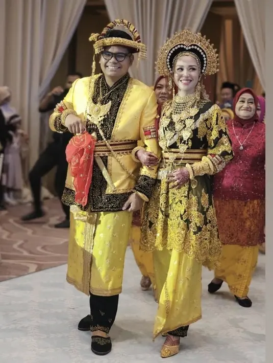 Saat resepsi pernikahan, keduanya tetap tampil mengenakan pakaian adat warna kuning. Lengkap dengan aksesori yang dikenakan. [@nendrahadaddo]