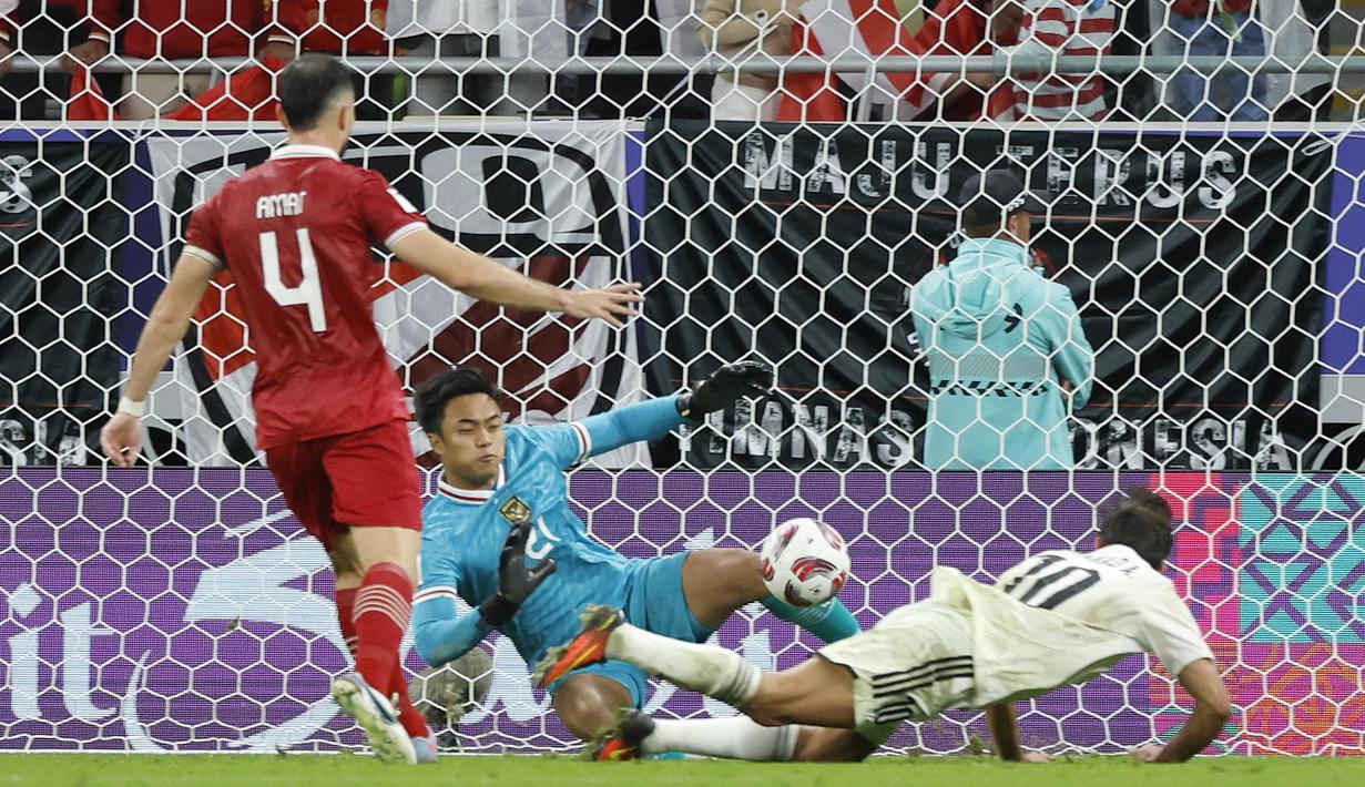 Indonesia memang menelan kekalahan dari Irak dengan skor 1-3. Namun penampilan Ernando Ari di bawah mistar gawang tak terlalu buruk. Ia sempat mencatatkan dua penyelamatan untuk mencegah gawangnya bobol lebih banyak. Ia juga sempat sekali berjibaku mengamankan areanya dari serbuan pemain lawan. (AFP/Karim Jaafar)