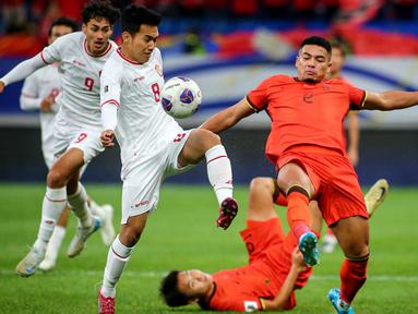 Pemain Timnas Indonesia, Witan Sulaeman (kiri) berebut bola dengan pemain China,&nbsp;Jiang Guangtai (kanan) saat laga lanjutan putaran ketiga Grup C Kualifikasi Piala Dunia 2026 di Qingdao Youth Stadium, Qingdao, China, Selasa (15/10/2024). (AFP)