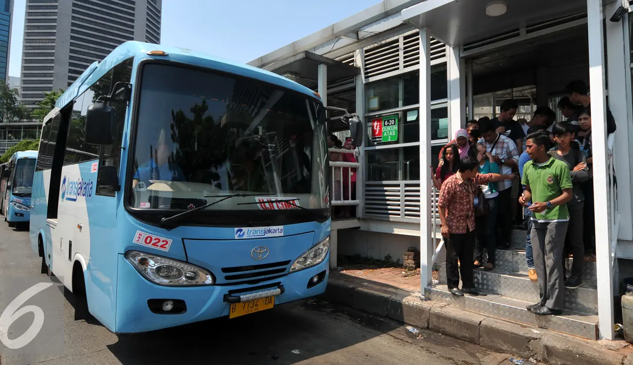 Penumpang tampak pada pintu tunggu masuk bus Transjakarta menuju Ragunan di Halte Dukuh Atas 2, Jakarta, Jumat (1/1/2016). Ratusan penumpang menumpuk menunggu bus TransJakarta tujuan Ragunan untuk menikmati libur panjang 2016. (Liputan6.com/Yoppy Renato)