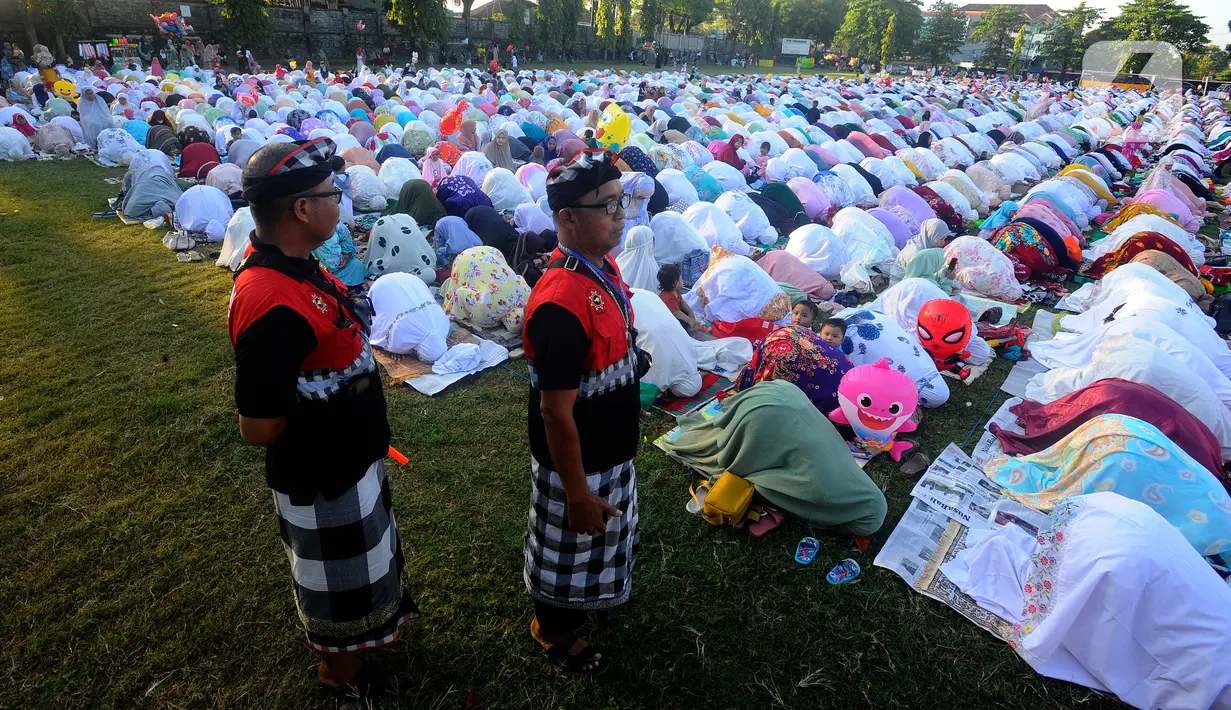 Pecalang dari Banjar Pegok berjaga saat umat muslim melakukan Sholat Idul Fitri di Lapangan Pegok, Sesetan, Denpasar, Sabtu (22/4/2023). (merdeka.com/Arie Basuki)