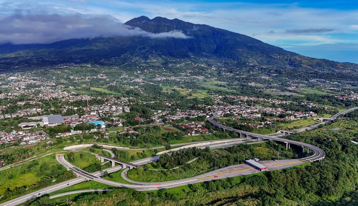 Foto udara memperlihatkan ruas Jalan Tol Bogor-Ciawi-Sukabumi (Bocimi) dengan latar belakang Gunung Salak di Cibadak, Kabupaten Sukabumi, Jawa Barat, Jumat (31/10/2025). Pembangunan jalan tol Bogor–Ciawi–Sukabumi (Bocimi) terus dikembangkan, dan kini memasuki seksi 3 yang menghubungkan Cibadak–Sukabumi Barat sepanjang 13,7 kilometer. (merdeka.com/Arie Basuki)