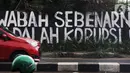 Pengendara melintas di depan mural yang berisi kritikan di Jalan Raya Bogor, Depok, Jawa Barat, Minggu (19/9/2021). Kritik terhadap pemerintah lewat coretan dinding atau mural sempat menjadi polemik karena dihapus. (Liputan6.com/Helmi Fithriansyah)