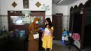 Tenaga kesehatan Siti Nurjanah memberikan vaksinasi campak dalam kampanye dari rumah ke rumah menyusul wabah di Sumenep, Pulau Madura, Jawa Timur, Senin 8 September 2025. (AP Photo/Dita Alangkara)