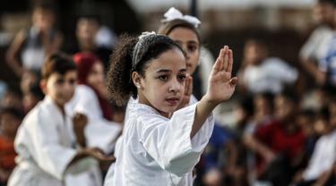Seorang anak Palestina menunjukkan keterampilannya selama upacara promosi Karate di sebuah pusat olahraga di kamp Rafah untuk pengungsi Palestina di Jalur Gaza selatan (20/9/2019). (AFP Photo/Said Khatib)