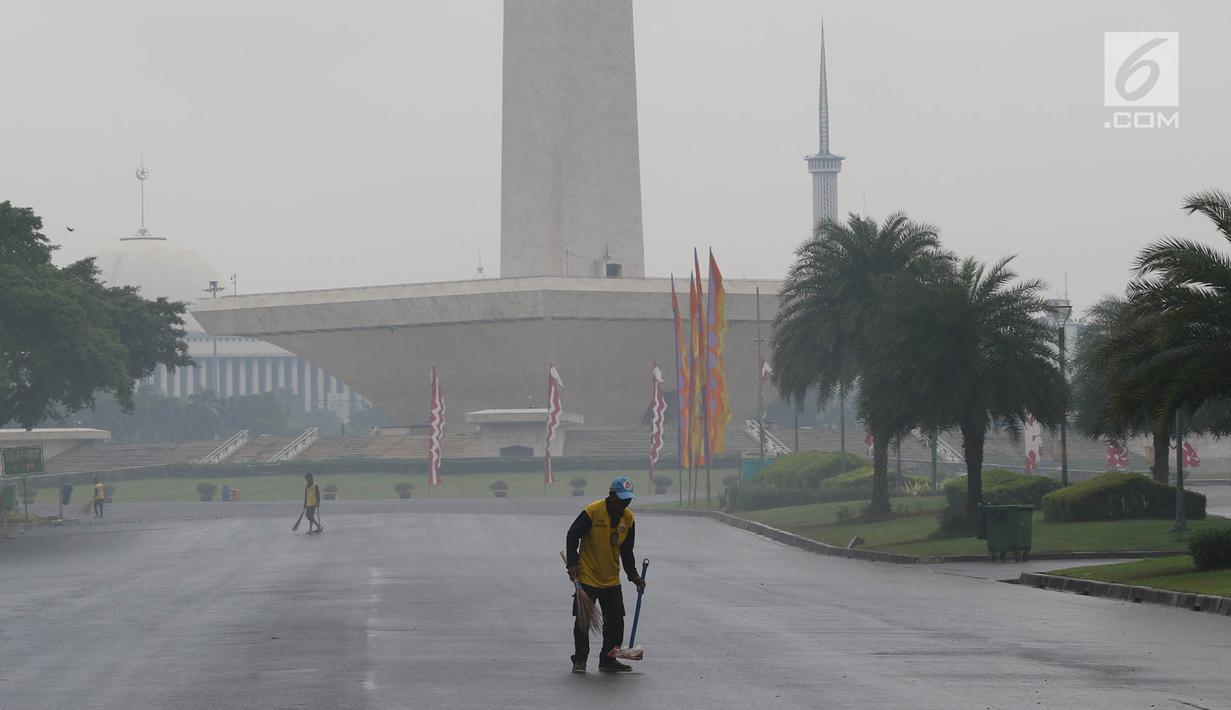 Petugas menyapu sampah yang tercecer di kawasan Monas, Jakarta, Senin (3/11). Kesigapan petugas kebersihan pasca reuni 212 membuat kawasan tersebut kembali bersih meskipun sehari sebelumnya dipenuhi ratusan ribu orang. (Liputan6.com/Immanuel Antonius)