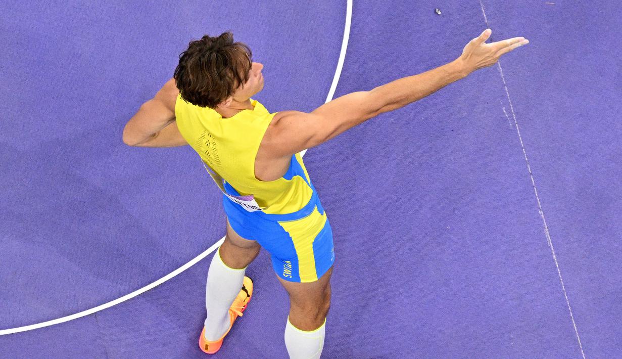 Atlet lompat galah Swedia, Armand Duplantis melakukakn selebrasi dengan menirukan gaya penembak Turki, Yusuf Dikec saat memastikan medali emas cabang olahraga lompat galah Olimpiade Paris 2024 di Stade de France, Paris, Prancis, Senin (05/08/2024) waktu setempat. (AFP/Antonin Thuillier)