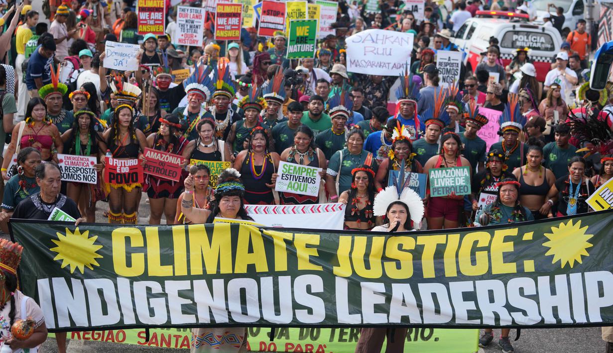 Aksi ini untuk menuntut perlindungan yang lebih baik terhadap hutan Amazon dan wilayah adat mereka dari eksploitasi industri. Tampak dalam foto, suku-suku asli ikut serta dalam aksi protes untuk keadilan iklim di tengah-tengah perhelatan Konferensi Tingkat Tinggi Perubahan Iklim PBB (COP30), di Belem, Brasil, Senin 17 November 2025. (AP Photo/Andre Penner)