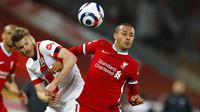 Penyerang Liverpool, Thiago Alcantara, duel udara dengan pemain Southampton, Nathan Redmond, pada laga Liga Inggris di Stadion Anfield, Minggu (9/5/2021). Liverpool menang dengan skor 2-0. (Phil Noble/Pool via AP)