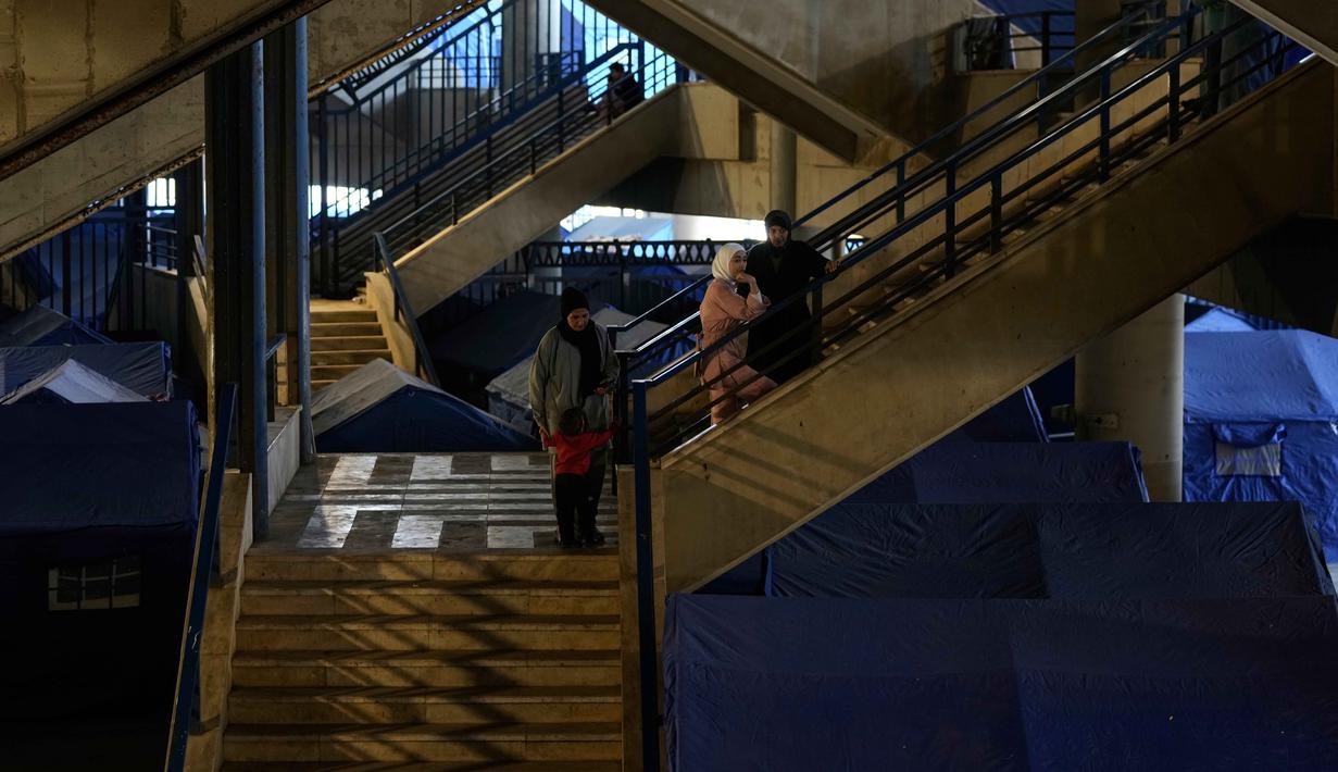 Sebagai informasi, melansir keterangan dari laman resmi Perserikatan Bangsa Bangsa (PBB), Senin (6/4/2026), Juru Bicara Sekretaris Jenderal PBB, Stephane Dujarric mengatakan krisis pengungsi di Lebanon semakin parah akibat operasi pengeboman dan serangan darat Israel yang berlangsung sejak awal Maret 2026 lalu. Tampak dalam foto, para perempuan pengungsi berdiri di Stadion Camille Chamoun Sports City Stadium, yang telah diubah menjadi tempat penampungan bagi orang-orang yang melarikan diri dari serangan udara Israel di Lebanon selatan, Beirut, Lebanon, Rabu 8 April 2026. (AP Photo/Bilal Hussein)