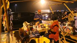 Seorang pemudik membeli makanan ringan yang dijajakan pedagang di pinggir Tol Cikopo, Jawa Barat, Jumat (1/7). Para pedagang dadakan yang menjajakan aneka makanan ringan dan minuman mulai menjamur di sepanjang jalur tersebut. (Liputan6.com/Angga Yuniar)