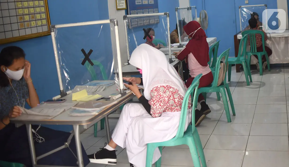 Sejumlah siswa mengikuti PJJ di Balai Warga RT 05/RW 02 Kelurahan Galur, Johar Baru, Jakarta, Selasa (15/8/2020). Program Internet Gratis untuk semua yang digalakan Pemprov DKI Jakarta ditujukan untuk mengatasi persoalan kesenjangan digital selama pandemi Covid-19. (Liputan6.com/Fery Pradolo)