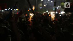 Peserta aksi unjuk rasa memegang lilin saat doa bersama lintas agama di Kawasan Patung Kuda, Jakarta, Selasa (10/11/2020). Sejumlah massa gabungan dari berbagai organisasi buruh dan mahasiswa berunjuk rasa menolak pengesahan Omnibus Law UU Cipta Kerja. (Liputan6.com/Helmi Fithriansyah)