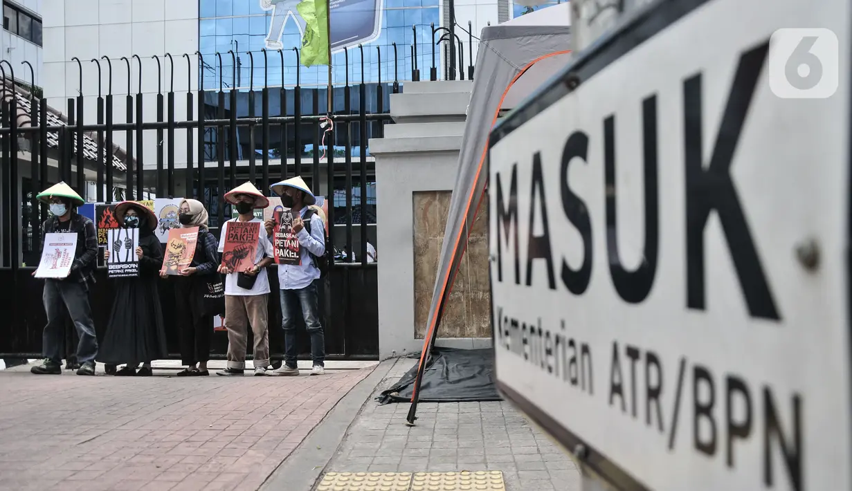 Aktivis Gerakan Rakyat untuk Kedaulatan Agraria membawa poster saat aksi mogok makan di depan Kantor Kementerian ATR/BPN, Jakarta, Senin (20/2/2023). Mereka juga menuntut Presiden Joko Widodo menyelesaikan kasus warga Pakel Banyuwangi dan memulihkan hak-hak ekonomi, sosial, budaya mereka yang terampas. (merdeka.com/Iqbal S Nugroho)