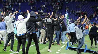 Suporter Espanyol bereaksi menyerbu lapangan atas kemenangan Barcelona setelah laga tandang pekan ke-34 La Liga 2022/2023 di RCDE Stadium, Senin (15/5/2023) dini hari WIB. (Photo by Lluis GENE / AFP)