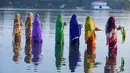 Sejumlah perempuan Hindu India membawa sesajen ketika berdoa pada matahari di tepi Danau Hussain Sagar di Hyderabad saat Festival Chhath untuk memuja dewa matahari, Selasa (17/11). (AFP PHOTO/NOAH Seelam)