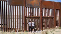 Seorang pemuda berhasil melewati tembok besi perbatasan antara Meksiko dan Amerika Serikat di negara bagian Chihuahua, Meksiko (6/4). Aksi nekat ini dapat ditindak tegas oleh pihak keamanan Amerika Serikat. (AFP/Herika Matinez)