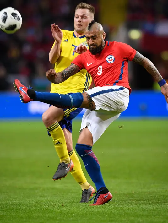 Gelandang Chile, Arturo Vidal berusaha membuang bola dari kawalan gelandang Swedia, Sebastian Larsson saat bertanding pada pertandingan persahabatan internasional Friends di Arena, Stockholm, (24/3). Chile menang 2-1. (Anders Wiklund/TT via AP)
