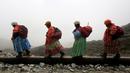 Perempuan suku Aymara saat mendaki Gunung Huayna Potosi, Bolivia (6/4). Perempuan suku Aymara yang berprofesi sebagai tukang masak dan angkut barang atau porter ini selalu mengenakan pakaian tradisional. (REUTERS/David Mercado)