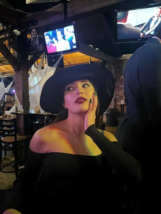Beby Tsabina saat berpose dengan busana serba hitam. Aktris cantik berusia 20 tahun itu memakai dress dan topi penyihir berwarna hitam yang mencuri perhatian. (Instagram/bebytsabina)